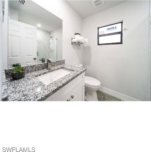 bathroom with vanity, a shower with shower door, and toilet