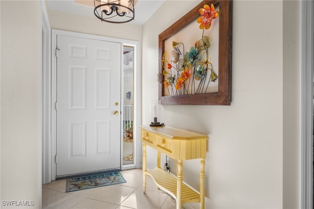 tiled entrance foyer with an inviting chandelier