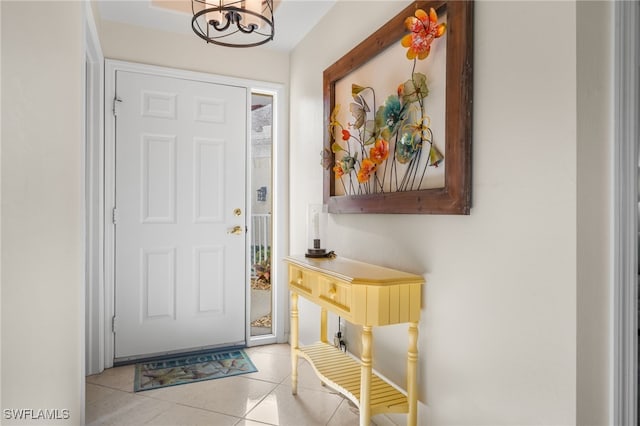 doorway to outside featuring an inviting chandelier and light tile patterned floors