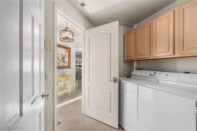 laundry room with washer and dryer, cabinets, and light tile patterned flooring