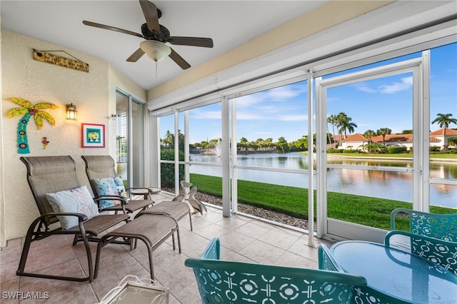 sunroom / solarium featuring a water view and ceiling fan