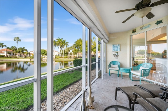 sunroom / solarium featuring plenty of natural light, ceiling fan, and a water view