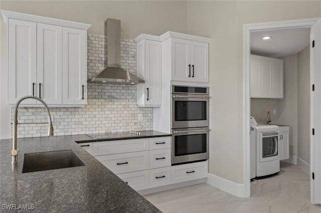 164 Colonade Cir Unit 1307, Naples, FL 34103 - kitchen featuring wall chimney exhaust hood, double oven, washing machine and clothes dryer, a sink, and marble finish floor