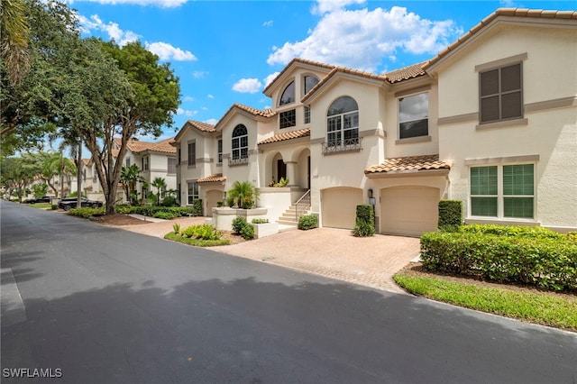 164 Colonade Cir Unit 1307, Naples, FL 34103 - mediterranean / spanish home with an attached garage, a tiled roof, stucco siding, and decorative driveway