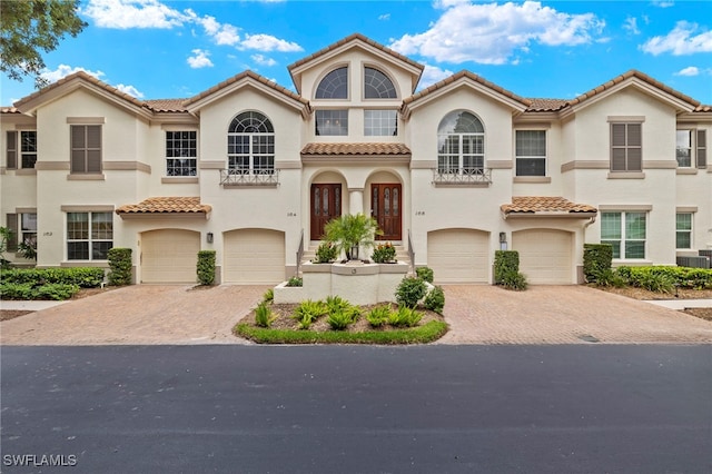 164 Colonade Cir Unit 1307, Naples, FL 34103 - mediterranean / spanish house featuring a tile roof, an attached garage, driveway, and stucco siding