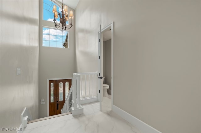 staircase featuring a high ceiling and an inviting chandelier