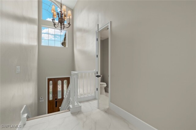 164 Colonade Cir Unit 1307, Naples, FL 34103 - entryway with a high ceiling, marble finish floor, a notable chandelier, and baseboards