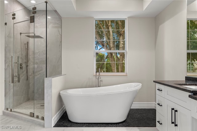 bathroom featuring vanity, independent shower and bath, and a wealth of natural light