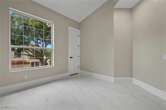 empty room with vaulted ceiling and a healthy amount of sunlight