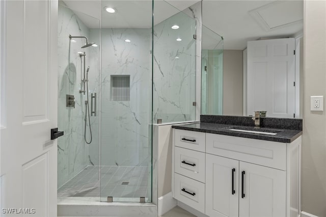 bathroom featuring vanity and a shower with door