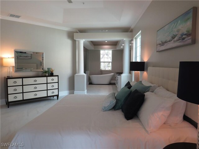 bedroom with ornamental molding, a tray ceiling, decorative columns, and light carpet