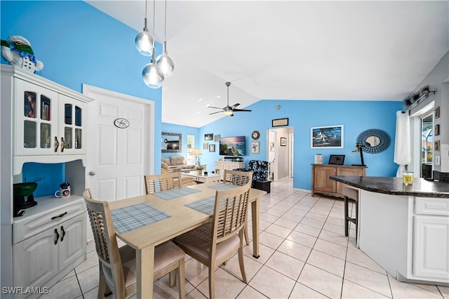 dining space with lofted ceiling, light tile patterned flooring, and ceiling fan