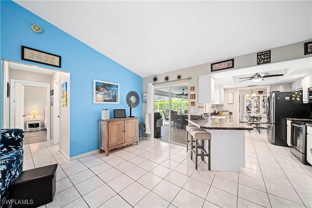 kitchen with white cabinetry, stainless steel range with electric stovetop, kitchen peninsula, ceiling fan, and a breakfast bar