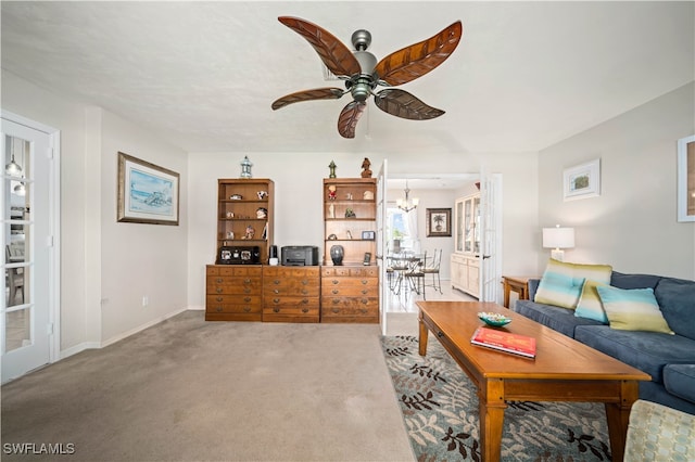 living room with carpet flooring and ceiling fan with notable chandelier