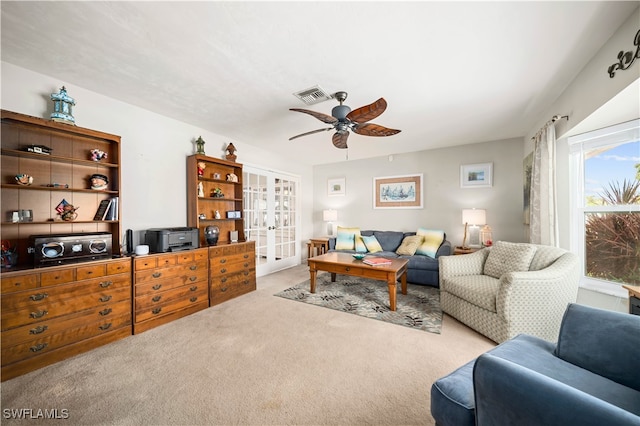 living room featuring light carpet, french doors, and ceiling fan