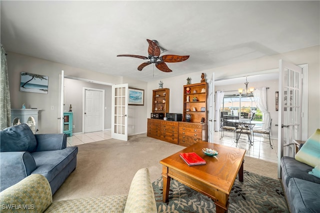 living room featuring light tile patterned floors, ceiling fan with notable chandelier, and french doors