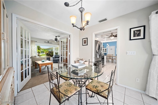 dining room with light tile patterned floors and ceiling fan with notable chandelier