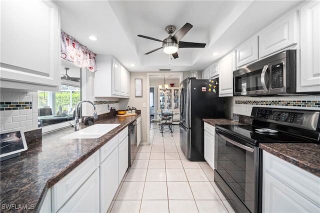 kitchen featuring ceiling fan with notable chandelier, black appliances, sink, white cabinetry, and dark stone countertops