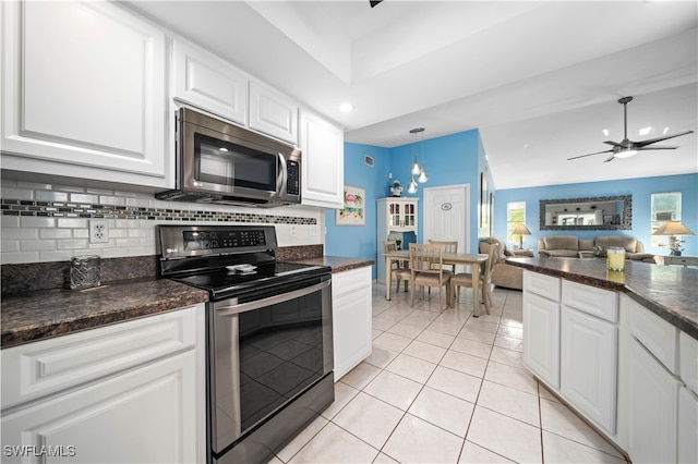 kitchen featuring ceiling fan with notable chandelier, white cabinets, range with electric stovetop, hanging light fixtures, and light tile patterned flooring