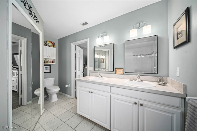 bathroom with vanity, toilet, a shower, and tile patterned flooring