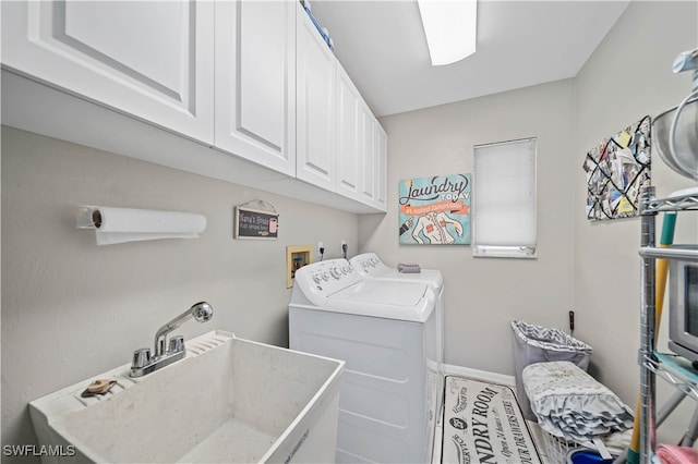 laundry room featuring separate washer and dryer, cabinets, and sink