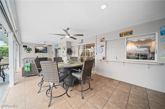 tiled dining space with plenty of natural light and ceiling fan