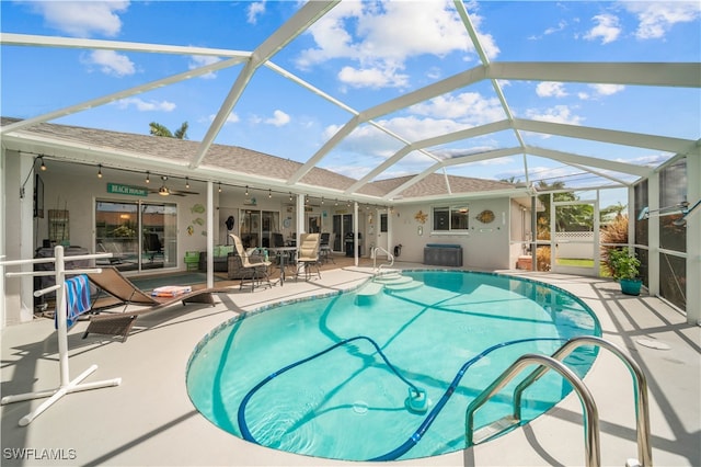 view of swimming pool with a lanai, ceiling fan, and a patio