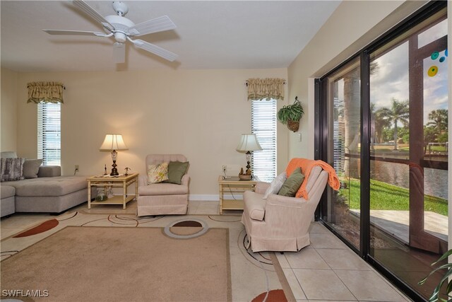living area with light tile patterned floors, ceiling fan, and a wealth of natural light