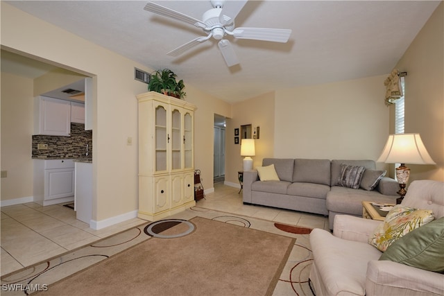 living area with baseboards, visible vents, ceiling fan, and light tile patterned floors