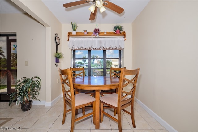 dining space with light tile patterned flooring, ceiling fan, and baseboards