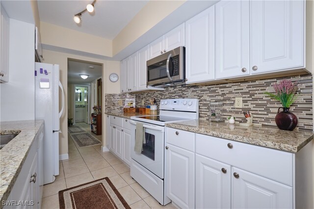 kitchen featuring white appliances, white cabinetry, and light stone counters