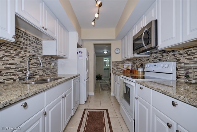 kitchen featuring white cabinetry, a sink, light tile patterned floors, and white appliances