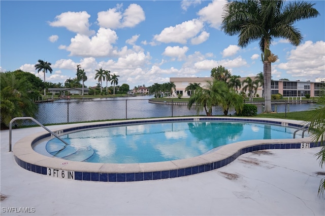 view of swimming pool with a water view and a patio area