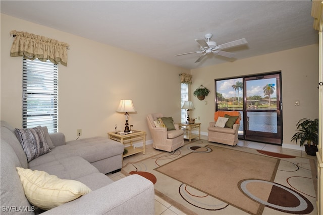 living area with baseboards, tile patterned flooring, and a ceiling fan