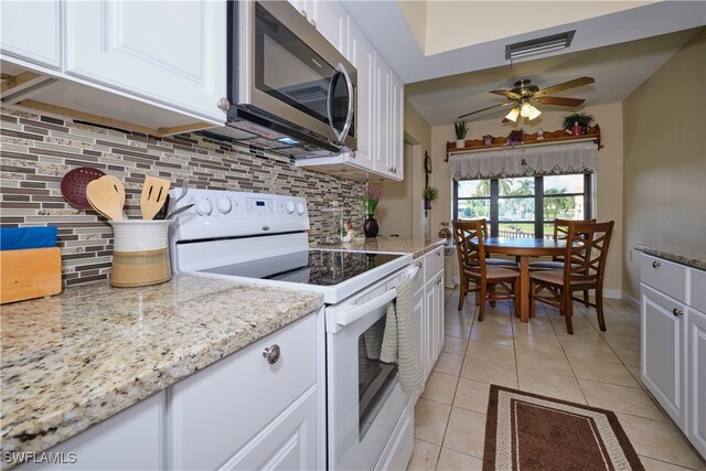 kitchen featuring white cabinetry, light stone counters, electric range, and light tile patterned flooring