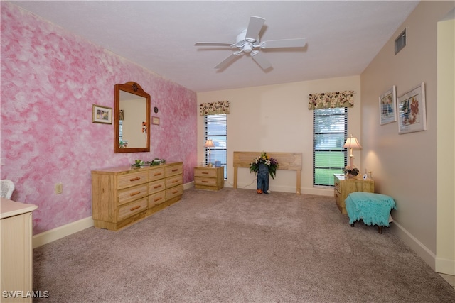 living area with carpet flooring, baseboards, wallpapered walls, visible vents, and a ceiling fan