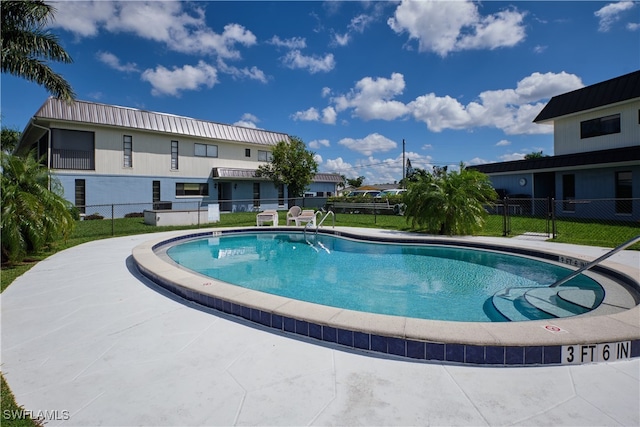community pool featuring a lawn and fence