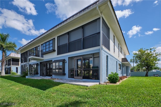 back of house featuring a patio, a yard, and a sunroom