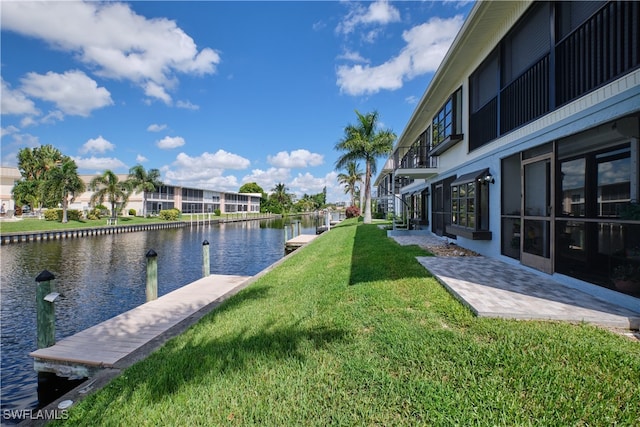 view of yard featuring a residential view, a water view, and a dock