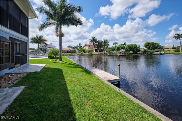 view of dock featuring a lawn and a water view