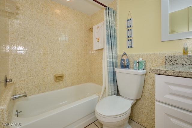 full bath featuring tile walls, toilet, tile patterned floors, vanity, and shower / bath combo with shower curtain