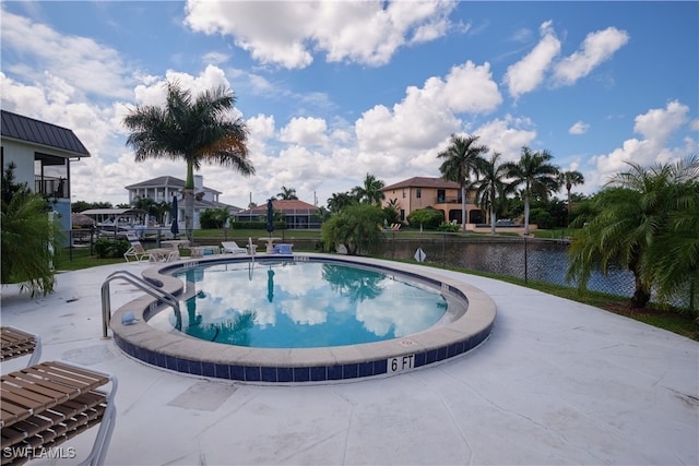 view of pool with a water view and a patio area