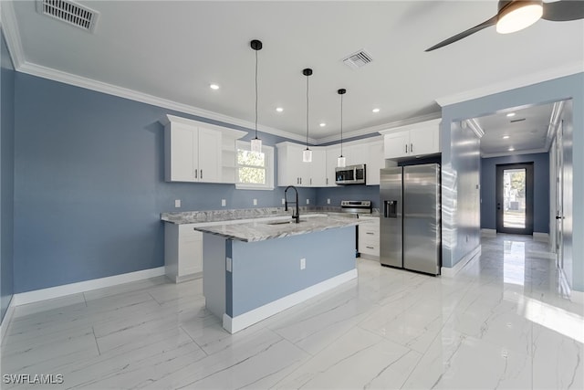 kitchen with a kitchen island with sink, hanging light fixtures, ornamental molding, white cabinets, and appliances with stainless steel finishes