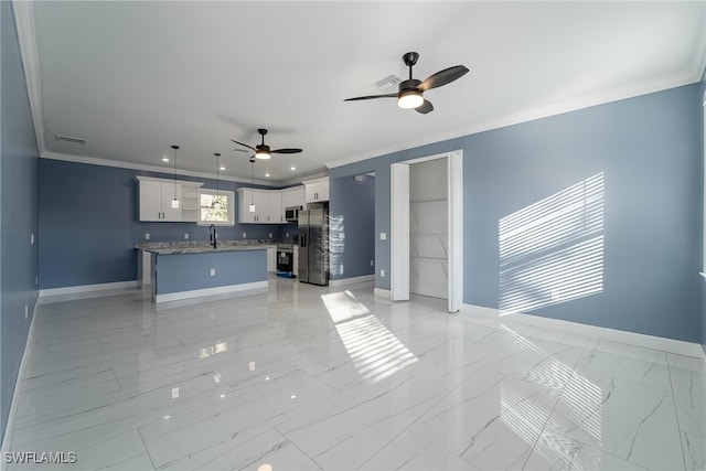 kitchen featuring appliances with stainless steel finishes, a kitchen island, hanging light fixtures, white cabinets, and crown molding