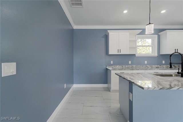 kitchen with white cabinets, light stone counters, sink, crown molding, and decorative light fixtures