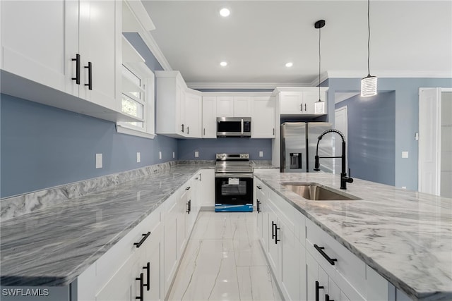 kitchen with white cabinetry, stainless steel appliances, sink, and an island with sink