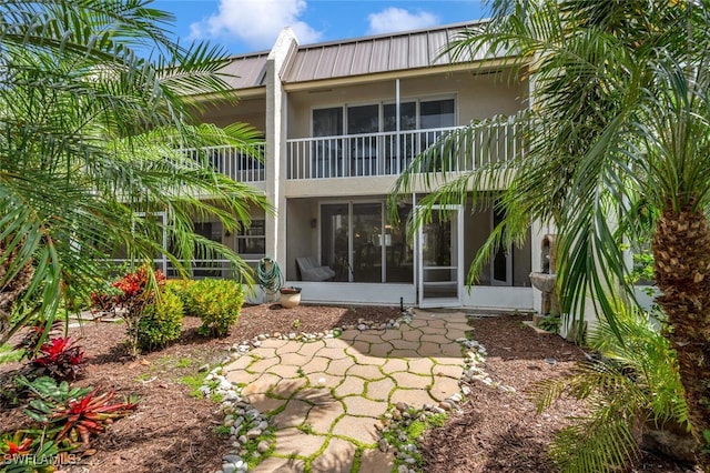 rear view of property with a balcony and a sunroom