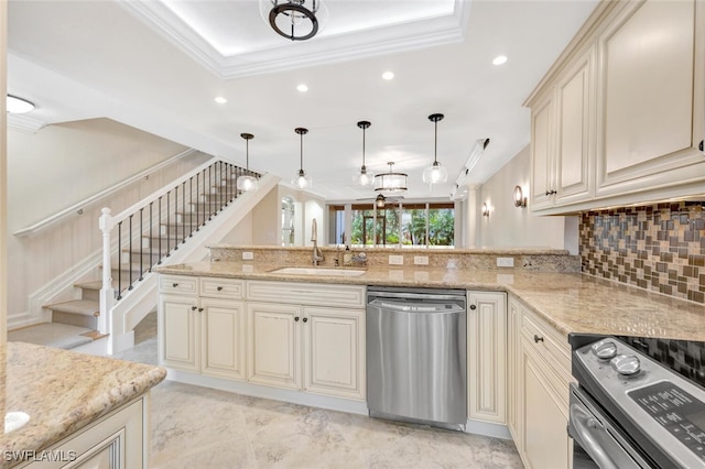 kitchen featuring sink, kitchen peninsula, decorative light fixtures, cream cabinetry, and appliances with stainless steel finishes