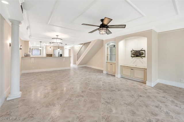 unfurnished living room with a raised ceiling, ceiling fan, and ornate columns