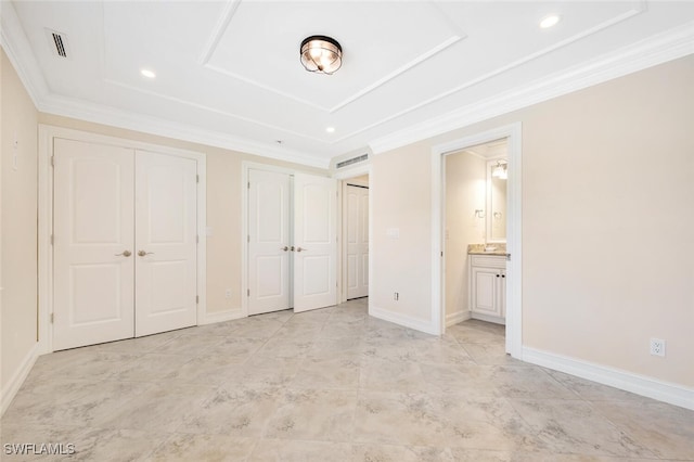 unfurnished bedroom with ornamental molding, two closets, and ensuite bathroom